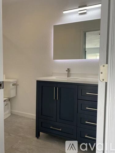 A bathroom with a sink, toilet, and a cabinet.