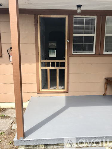 A door with a window above it and a light on the wall to the left.