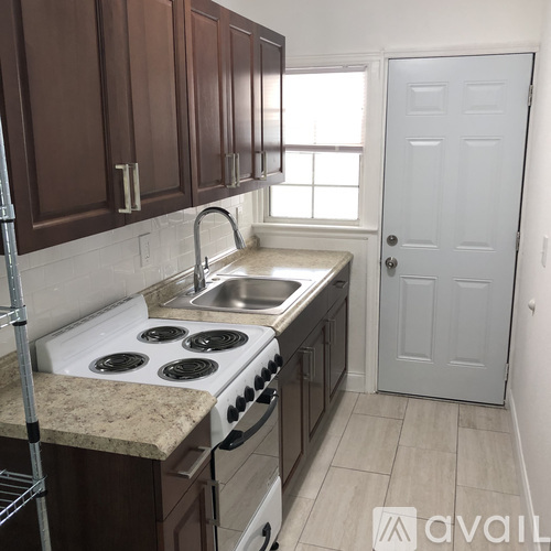 A kitchen with brown cabinets and a white stove top oven.