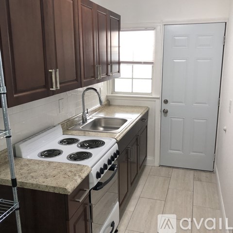 A kitchen with brown cabinets and a white stove top oven.