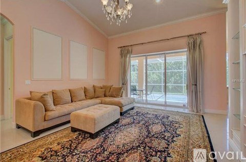 A living room with a beige sofa and a chandelier.