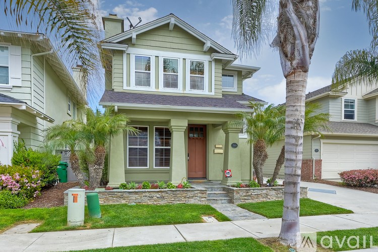 A house with a green front yard and a brown door.