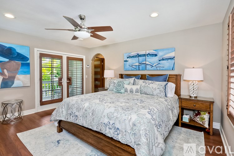 A bedroom with a large bed and a ceiling fan.