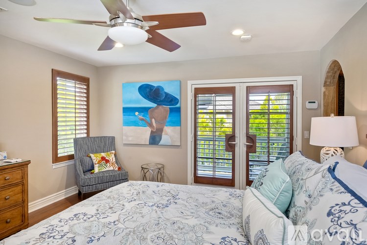 A bedroom with a large bed and a ceiling fan.