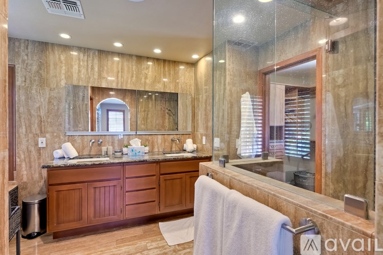 A bathroom with a large mirror and a white towel hanging on the railing.