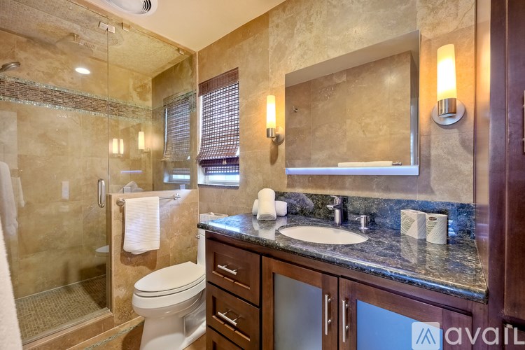 A bathroom with a toilet, sink, and shower.