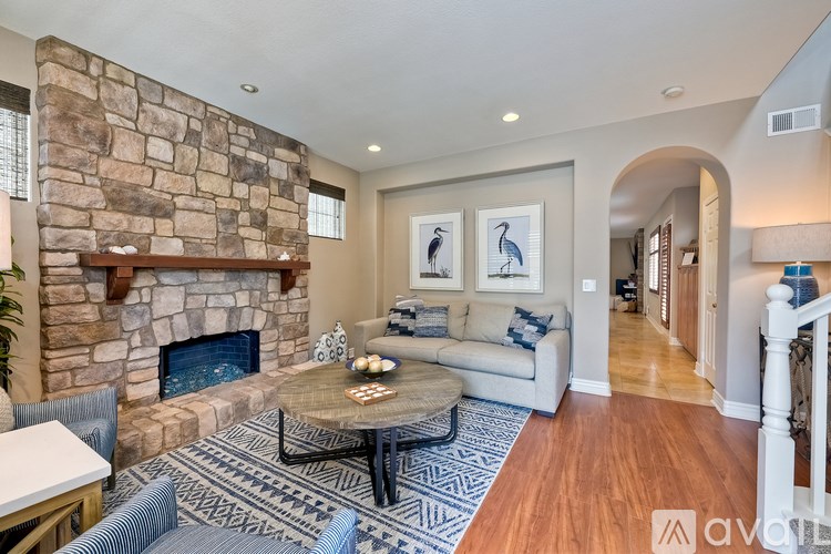 A living room with a stone fireplace and a couch.