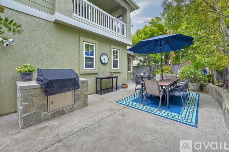 A patio with a table and chairs under an umbrella.