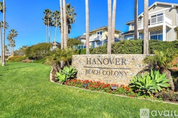 A sign that says Hanover Beach Colony in front of some houses.