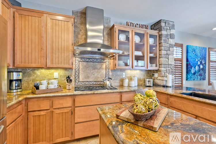 A kitchen with wooden cabinets and a stone backsplash.