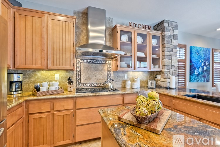 A kitchen with wooden cabinets and a stone backsplash.