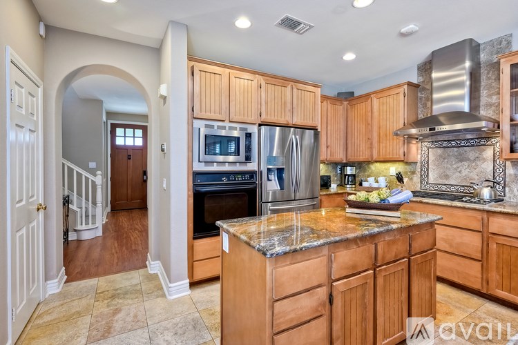 A kitchen with wooden cabinets and a granite countertop.