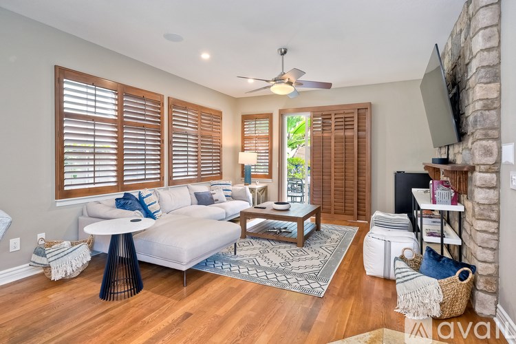 A living room with a white couch, a coffee table, and a ceiling fan.