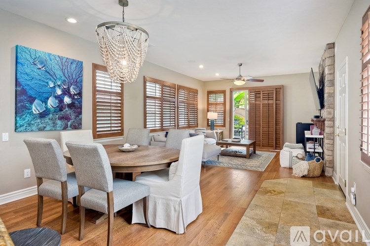 A dining room with a wooden table and chairs.
