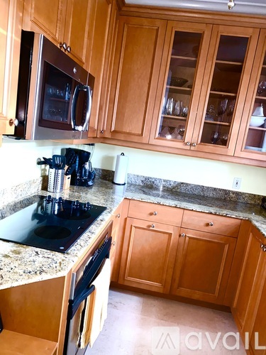 A kitchen with wooden cabinets and granite countertops.