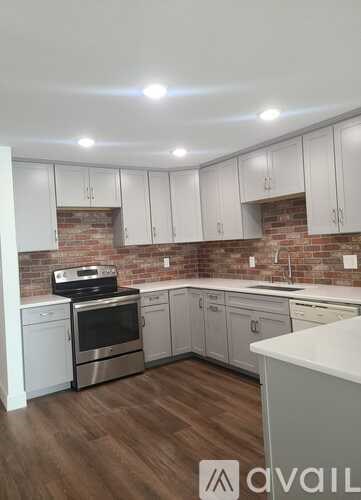 A kitchen with white cabinets and a brick backsplash.