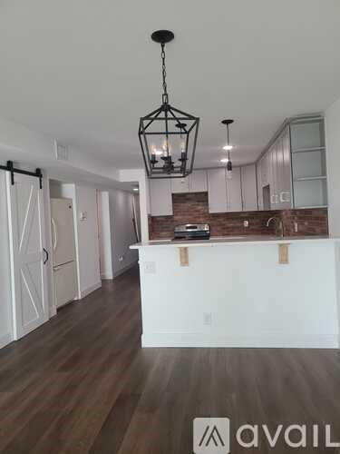 A modern kitchen with white cabinets and a wooden island.