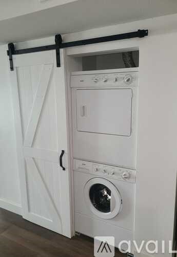 A white washing machine is installed in a cabinet.