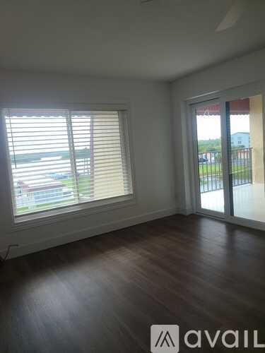 A room with wooden floors and a window with blinds.