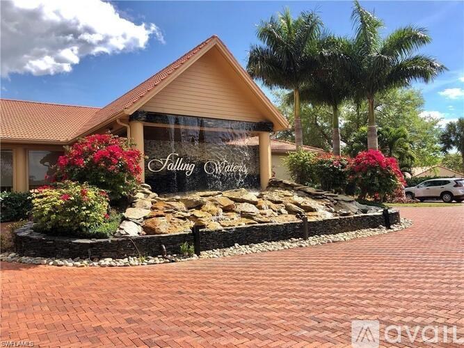 A house with a sign that says "Falling Waters" in front of it.