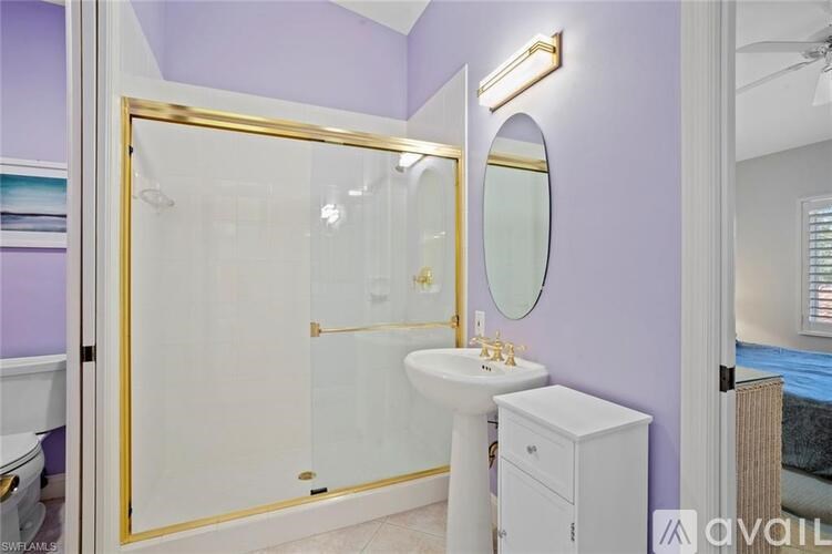 A bathroom with purple walls and a white sink.