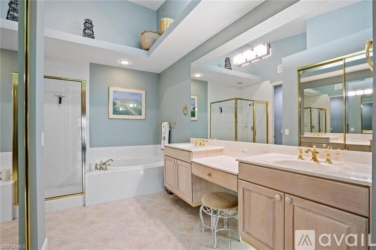A bathroom with a large mirror, a sink, and a shower.