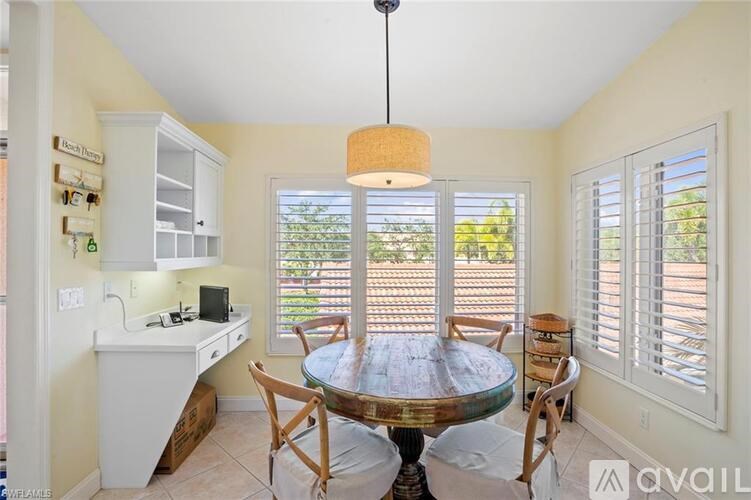A kitchen with a table and chairs in front of a window.