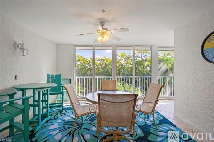 A room with a table and chairs and a ceiling fan.