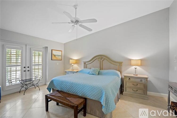 A bedroom with a bed, nightstand, and chair.