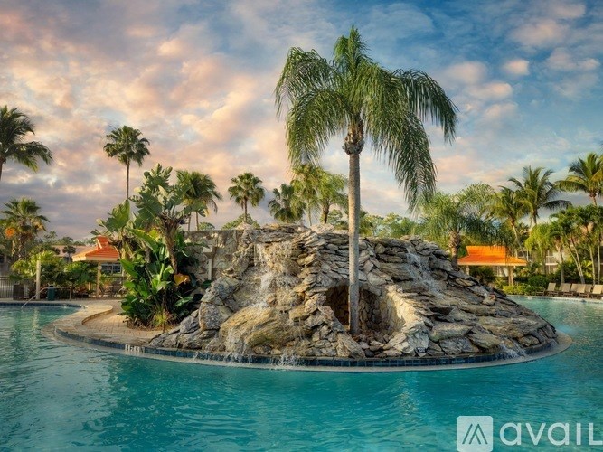 A palm tree stands on a rocky outcrop in the middle of a pool.