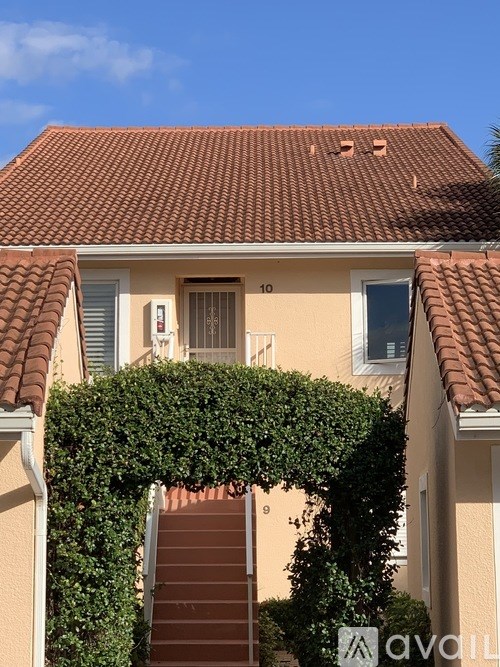 A house with a red tiled roof and a number 10 on the front door.