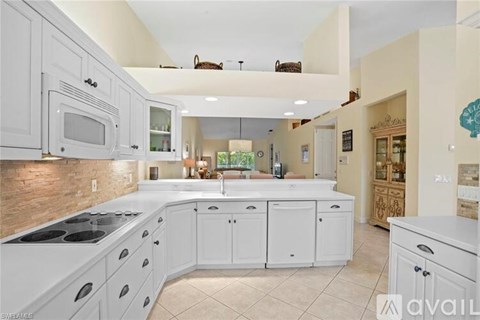 A kitchen with white cabinets and appliances.