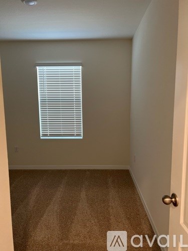 A room with a door and a window with blinds.