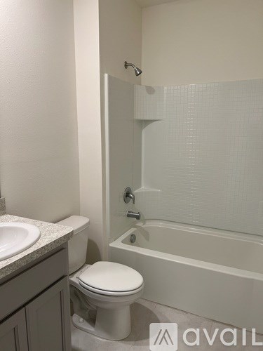 A white toilet sits next to a sink in a bathroom.