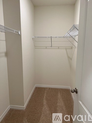 A hallway with a carpeted floor and white walls.