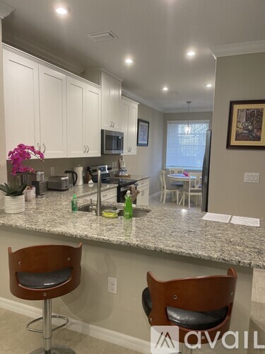 A kitchen with granite countertops and white cabinets.
