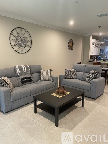 A living room with grey couches and a wooden coffee table.