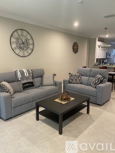 A living room with grey couches and a wooden coffee table.