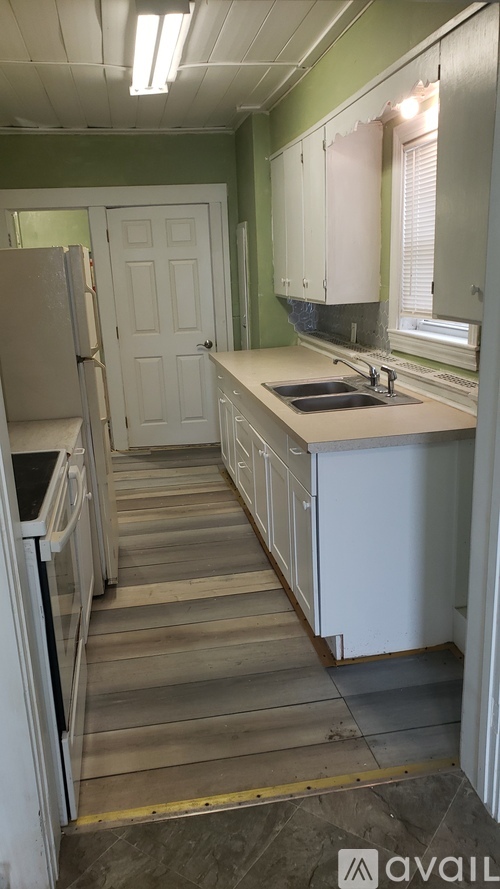 A kitchen with green walls and white appliances.