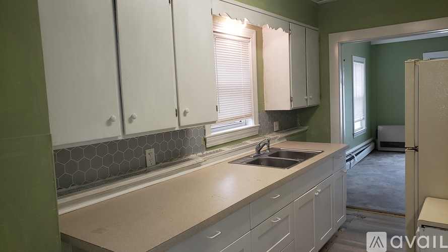 A kitchen with white cabinets and a sink.