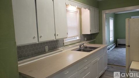 A kitchen with white cabinets and a sink.