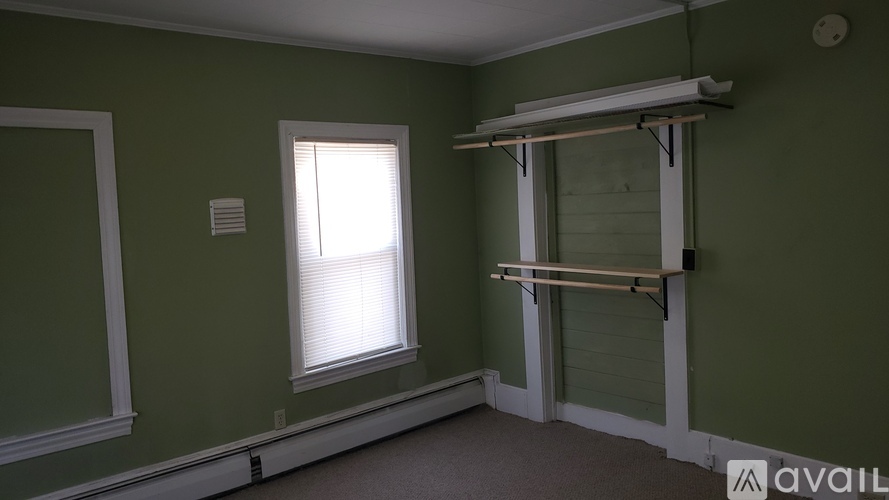 A room with green walls and a window.