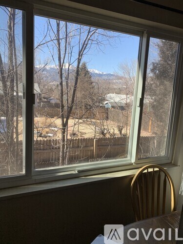 A chair is in front of a window looking out at a snowy landscape.