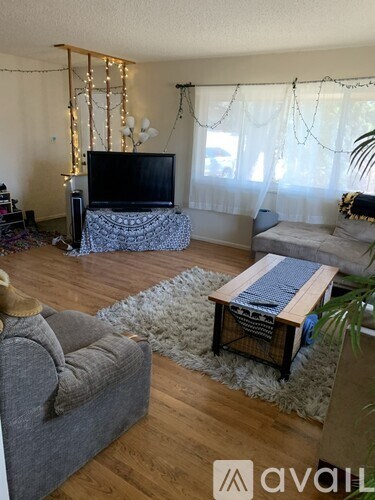 A living room with a grey couch, a wooden coffee table, and a television.