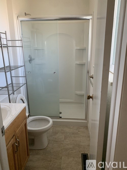 A bathroom with a toilet, sink, and shower.