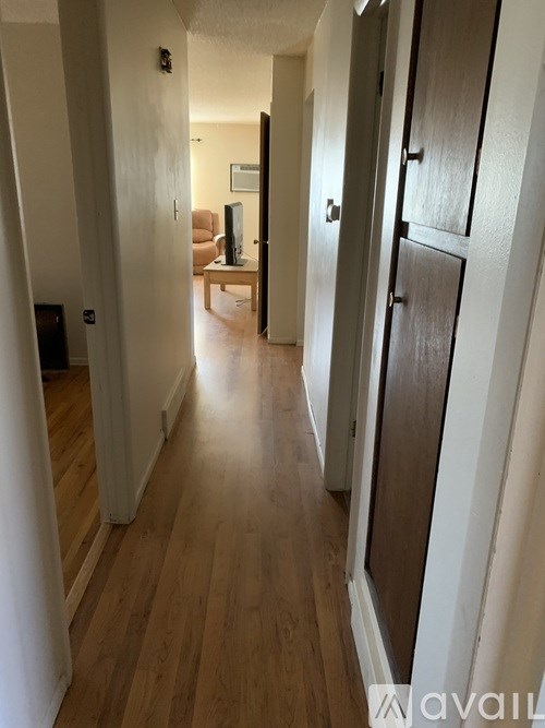A long hallway with a brown door on the right.