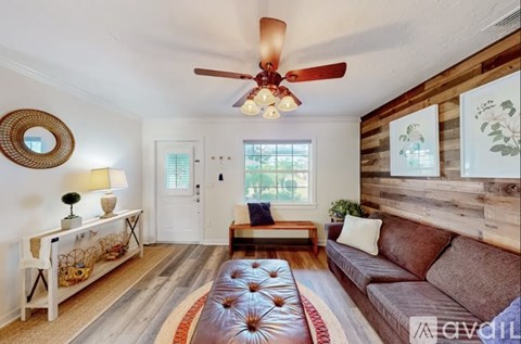 A living room with a brown couch and a wooden wall.