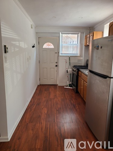 A kitchen with a table and chairs and a refrigerator.