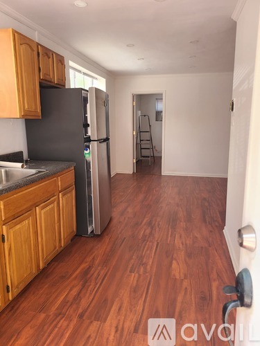 A kitchen with wooden cabinets and a stainless steel refrigerator.