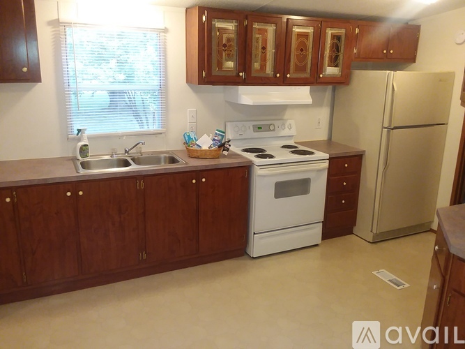 A kitchen with wooden cabinets and a white stove top oven.